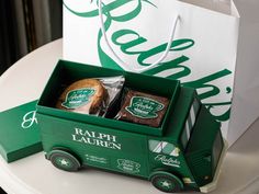 a green box with some food in it on a table next to a paper bag