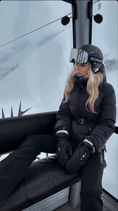 a woman sitting on top of a ski lift