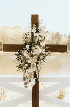 a cross decorated with flowers and greenery