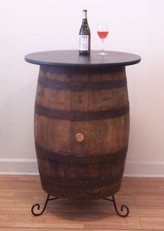 a wooden barrel table with a wine glass on top