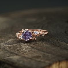 a close up of a ring on top of a piece of wood with a stone in the middle