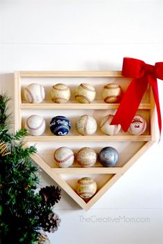 a wooden shelf with baseballs on it and a red bow hanging from the top