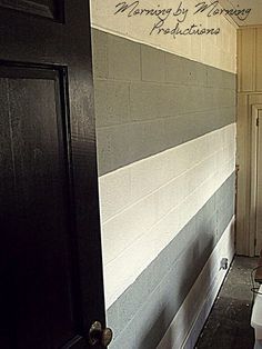 a bathroom door is open to reveal the toilet in the room that has been painted black and white