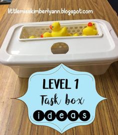 the level 1 task box has three rubber ducks in it and is on top of a wooden table