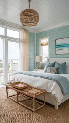 a bedroom with blue walls, white bedding and a wicker basket on the end table