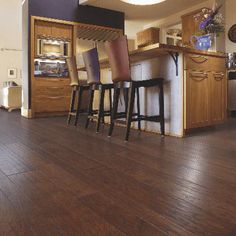 a kitchen with wooden floors and bar stools