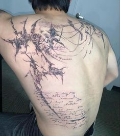 the back of a man's tattoo with writing all over his upper and lower back