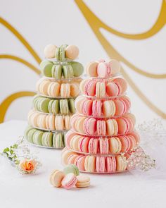 two stacks of macaroons sitting next to each other on top of a table