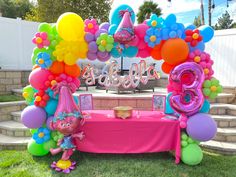 an outdoor birthday party with balloons and decorations