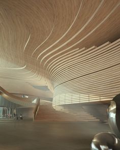 an artisticly designed building with wooden slats on the ceiling and stairs leading up to it