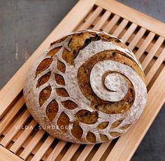 two loaves of bread sitting on top of a wooden tray