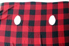 two holes in the fabric that is red and black with white circles on them are visible