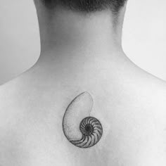 a black and white photo of a man's back with a tattoo on it