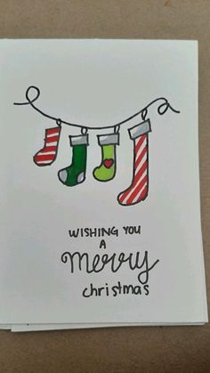 a christmas card with stockings hanging from a line and the words wishing you merry christmas