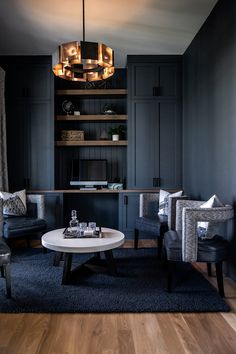 a living room with two chairs and a coffee table in front of a book shelf