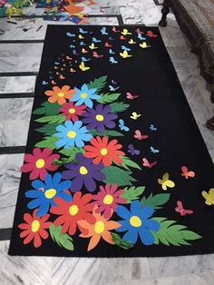 a black rug with colorful flowers and butterflies on it in the middle of a room