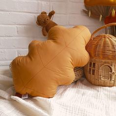 two stuffed animals sitting on top of a bed next to pillows and baskets in front of a white brick wall