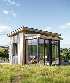 a small building sitting on top of a lush green field