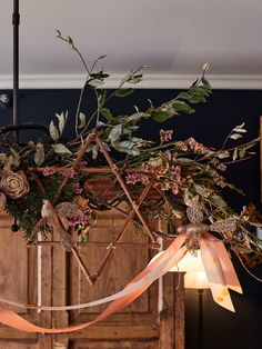 a chandelier with flowers and ribbons hanging from it