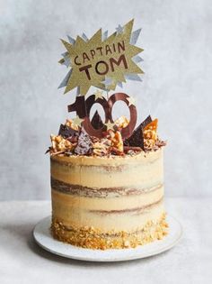 a cake that is sitting on top of a plate with the word captain tom spelled out