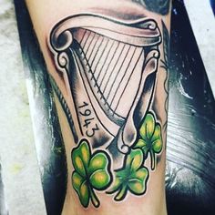 a tattoo with shamrocks and a harp on it