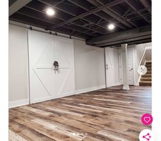 an empty room with wooden floors and white doors