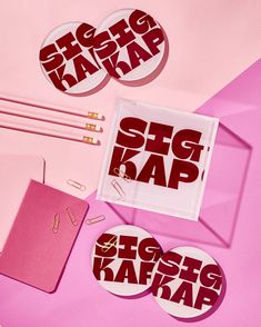 various stationery items displayed on pink background