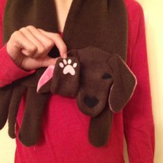 a woman in a red shirt is holding a brown and white dog shaped plush toy