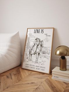 a poster on the floor next to a lamp and bed in a room with white walls