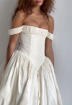 a woman in a white wedding dress posing for the camera with her hands on her hips