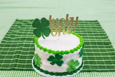 a green and white cake with shamrock decorations