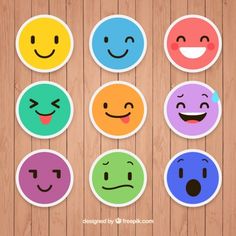 six different colored smiley faces on a wooden surface with the words happy written below them