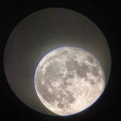 the full moon is seen through a circular window