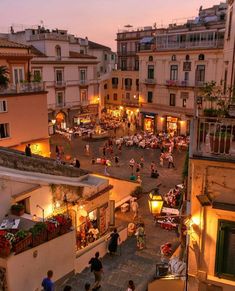 an aerial view of people sitting and walking around in the city at sunset or dawn