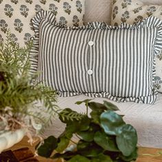 a white bed topped with pillows and plants