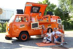 some people are sitting in front of an orange truck