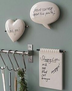 there are three white hearts hanging on the wall next to each other with writing on them