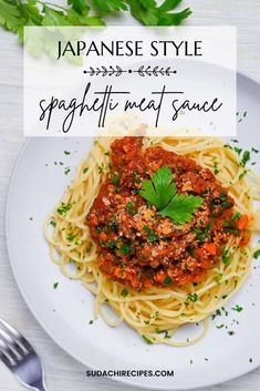 japanese style spaghetti meat sauce on a white plate with a fork and parsley in the background