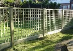 a white fence in the grass next to a house