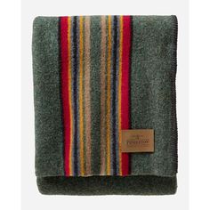 the pendleton blanket is made from wool and has multicolored stripes on it, as well as a leather tag