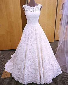 a white wedding dress on display in front of a mirror