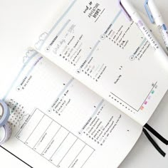 an open planner with two rolls of tape next to it