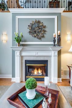 a living room filled with furniture and a fire place in front of a wall mounted fireplace