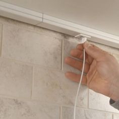 a hand is plugging in to a wall outlet