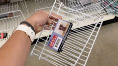 a person is holding a card in a wire rack