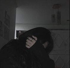 a woman covering her face in the dark