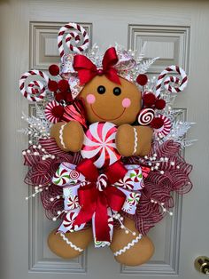 a gingerbread christmas wreath with candy canes and candies on the front door