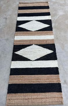 a black and white rug on the floor with an arrow design in the middle,