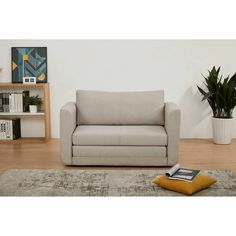 a couch sitting on top of a wooden floor next to a potted plant