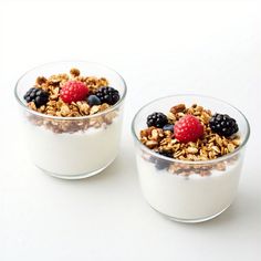 two small bowls filled with granola and berries